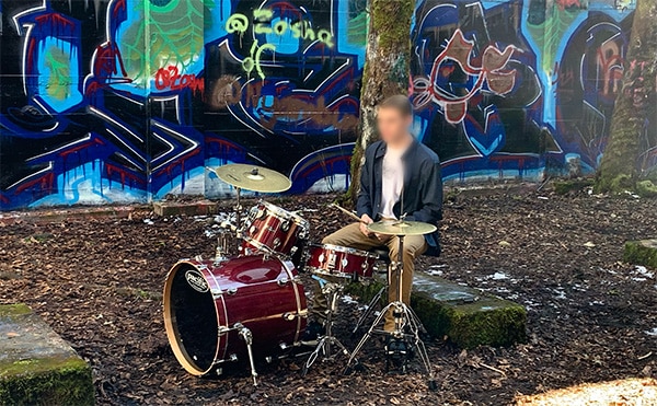 Young man playing drums inside old sawmill building, Vernonia, Oregon.